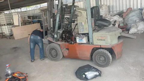 Teknisi PSM melakukan service mesin forklift Nissan di dalam gudang klien